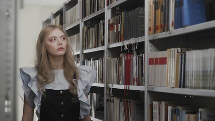 Beautiful young blonde student girl in school library