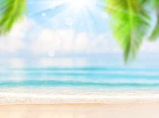 Fototapeta na wymiar Blurred blue sky and sea with bokeh light and leaves of coconut palm tree.