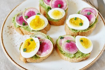 watermelon radish sandwich with avocado and egg. healthy balanced breakfast. bright toast