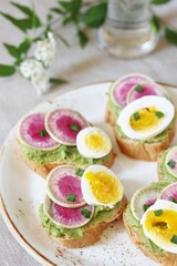 watermelon radish sandwich with avocado and egg. healthy balanced breakfast. bright toast