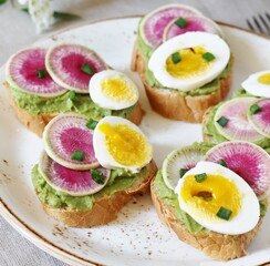 watermelon radish sandwich with avocado and egg. healthy balanced breakfast. bright toast