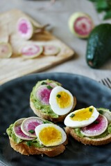 watermelon radish sandwich with avocado and egg. healthy balanced breakfast. bright toast