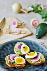 watermelon radish sandwich with avocado and egg. healthy balanced breakfast. bright toast