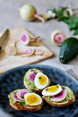 watermelon radish sandwich with avocado and egg. healthy balanced breakfast. bright toast