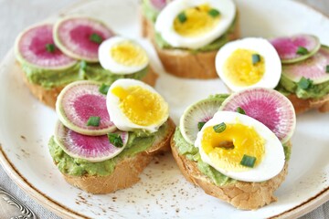 watermelon radish sandwich with avocado and egg. healthy balanced breakfast. bright toast