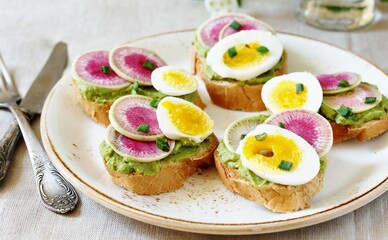 watermelon radish sandwich with avocado and egg. healthy balanced breakfast. bright toast