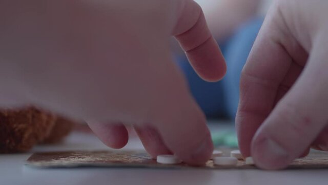 Kid plays with scattering medicine drugs. Toddler touches pills without parent control. Dangerous situation.