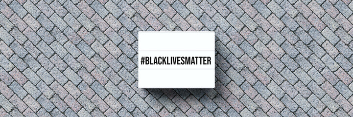 lightbox with message #BLACKLIVESMATTER on stone pavement background