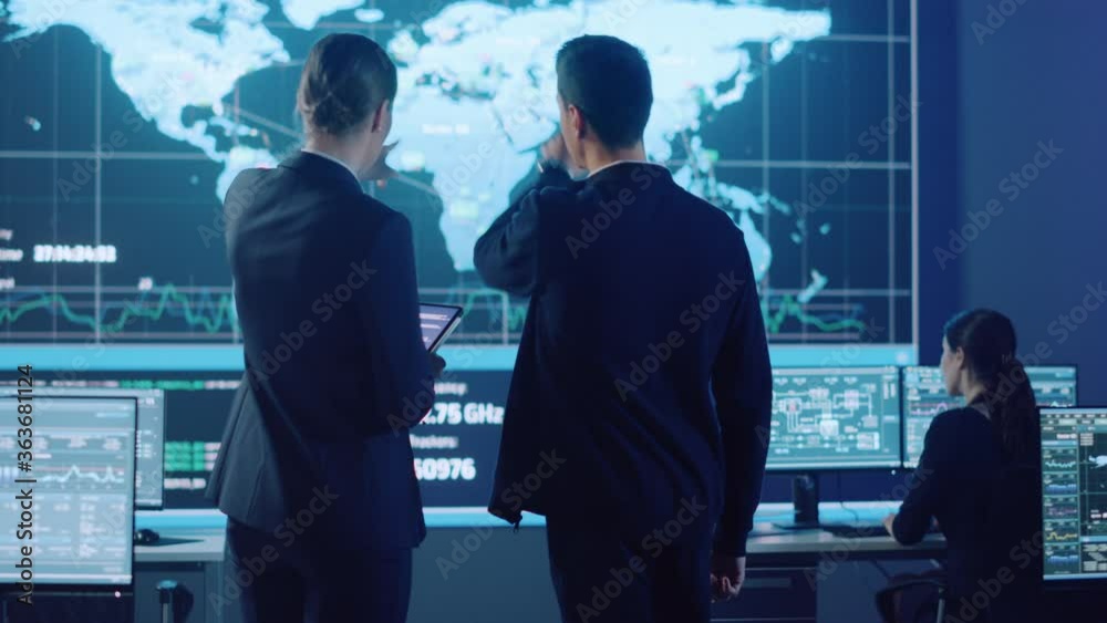 Poster Project Manager and Computer Science Engineer Talking while Using A Digital Tablet Computer. Telecommunications Company System Control and Monitoring Office Room with Working Specialists.