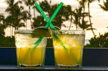 Romantic tropical cocktail with lime and an ocean view sunset.