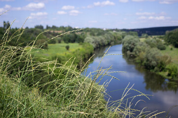 Beautiful landscape near Vinnytsia, Southern Bug river. Summer, sky with clouds. Grass in the foreground