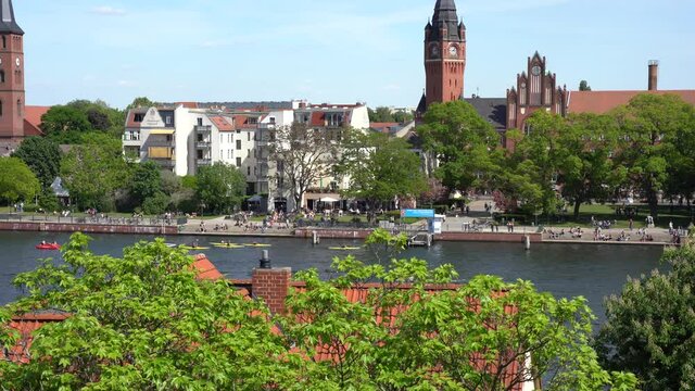 District K&ouml;penick in Berlin, Germany crowd of people outdoor kayaking, boating and recreation in front of old town city hall park on river