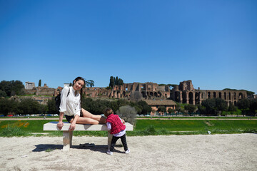 mother and daughter play on a bench in the street