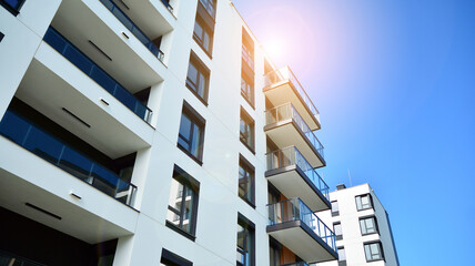 Modern apartment buildings on a sunny day with a blue sky. Facade of a modern apartment building. Glass surface with sunlight.