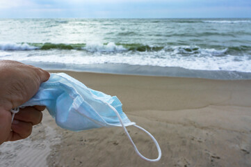Fototapeta na wymiar Medical mask at sea. Sea beach and sanitary mask.