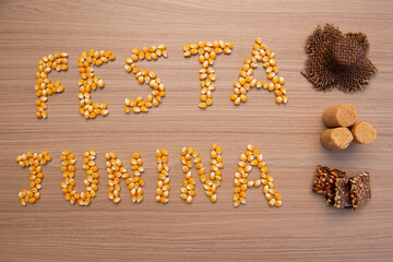 June party (Festa Junina) written with corn grains on wood. Traditional Brazilian festival celebrated between June and July. Country party with typical foods.