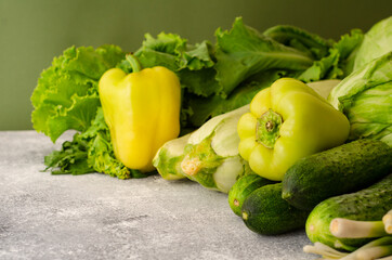 Healthy vegetarian food concept background, fresh green food selection for detox diet, raw  cucumber, zucchini, cabbage, yellow pepper, salad and , top view