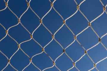 Fototapeta premium Tela de fios de nylon. Proteção para janelas de apartamento. Céu azul ao fundo.