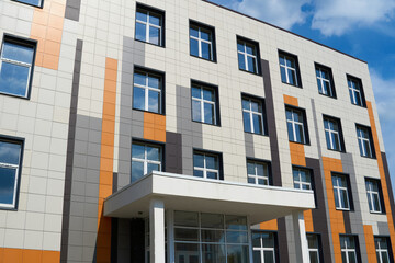 facade of a modern building on a bright Sunny day, siding and Windows, beautiful exterior of the new building