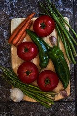 Vegetarian still life with tomatoes, green peppers, asparagus, carrots and garlic
