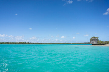 Beautiful seascape of Upi Bay, Pines Island, new caledonia: turquoise lagoon, lush vegetation, blue sky. 