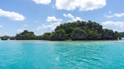 Beautiful seascape of Upi Bay, Pines Island, new caledonia: turquoise lagoon, typical rocks, lush vegetation, blue sky