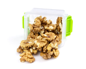 Kernels walnut isolated on a white background. Peeled walnut in a container.Healthy food. Plastic container with walnut.