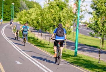 Fototapeta premium Cyclists ride on the bike path in the city Park 