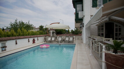 Ring floating in a refreshing blue swimming pool with waves reflecting in the summer sun. Active vacation background. Lifesaver for kid.	