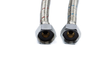 Metal hoses connecting hot and cold water on a white background, selective focus