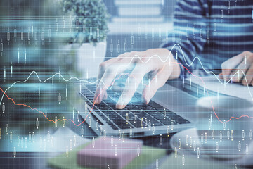 Double exposure of woman hands typing on computer and forex chart hologram drawing. Stock market...