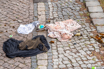 Pollution - Cover, T-shirt, broken beer bottle and cigar butts carelessly disposed on the street.