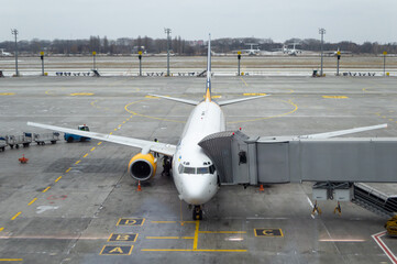Air plane with jet bridge connected, ready to receive passengers at the airport. air plane at...