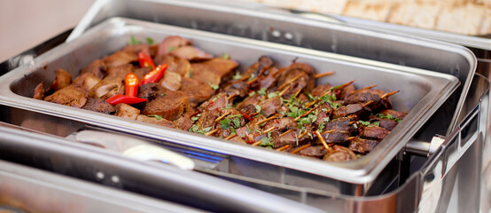 Stainless hotel pans on food warmers with various meals. . Self-service buffet table. Celebration,party,wedding