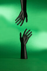 Black mannequin hands reaching for each other