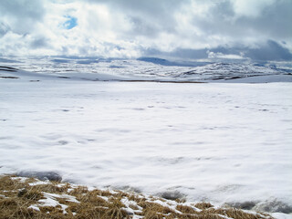 Beautiful winter lanscape. High in the mountains. Clouds lie on the snowy land, Norway.