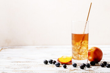 Cup of peach ice tea served with fresh peach