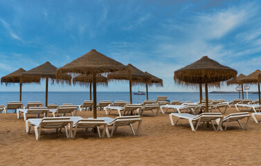 Empty beach with umbrellas and chairs.