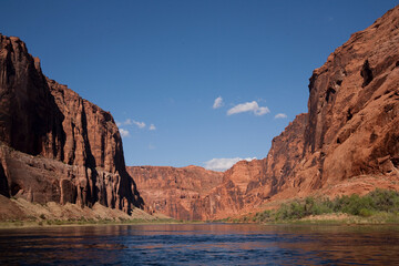 Fototapeta na wymiar On the Colorado River floating through the rust colored Grand Canyon framed by the blue sky above