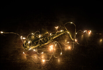 Alto gold sax miniature with colorful toned light on foggy background. Saxophone music instrument in lowlight. Selective focus