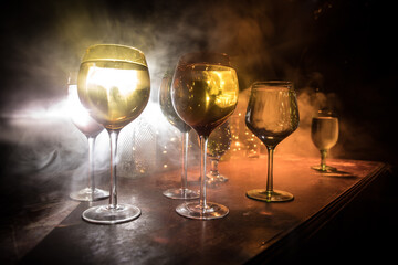 Goblet of white wine on wooden table on wooden wall background