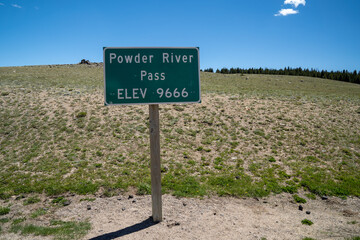Powder River Pass, elevation 9666 feet, sign on the highest point of the Cloud Peak Skyway (US Highway 16) in the Bighorn National Forest of Wyoming in summer