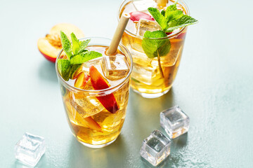 Iced tea with peach and ice cubes