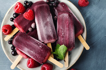 Popsicles with berries served on plate