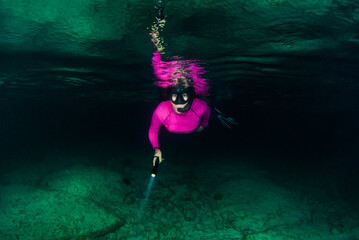 Obraz premium An adventurous young lady snorkeling in the ocean at night