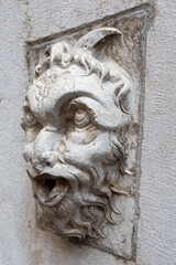 Obraz premium Bas-relief head positioned on a fountain located in Cortile Federico II - Piazza del Comune, Cremona