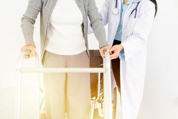 walk training and rehabilitation process, old asian stroke patient learning to uses walker with...