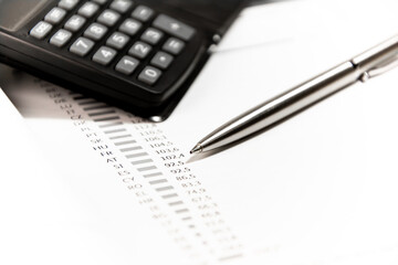 Pen and calculator on financial statement form. Finance concept.