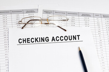 Checking account inscription on a sheet of paper against the background of glasses, pens and calculations.