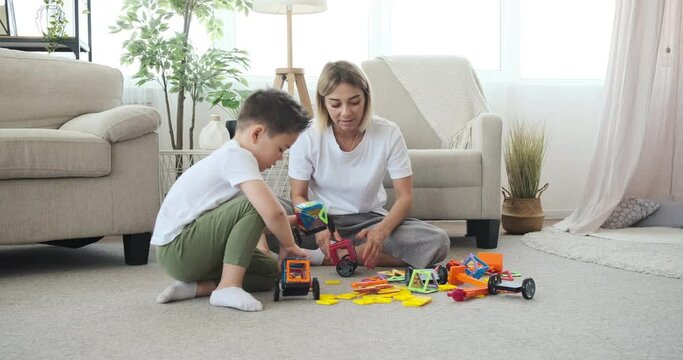 Mother and son assembling toy car at home